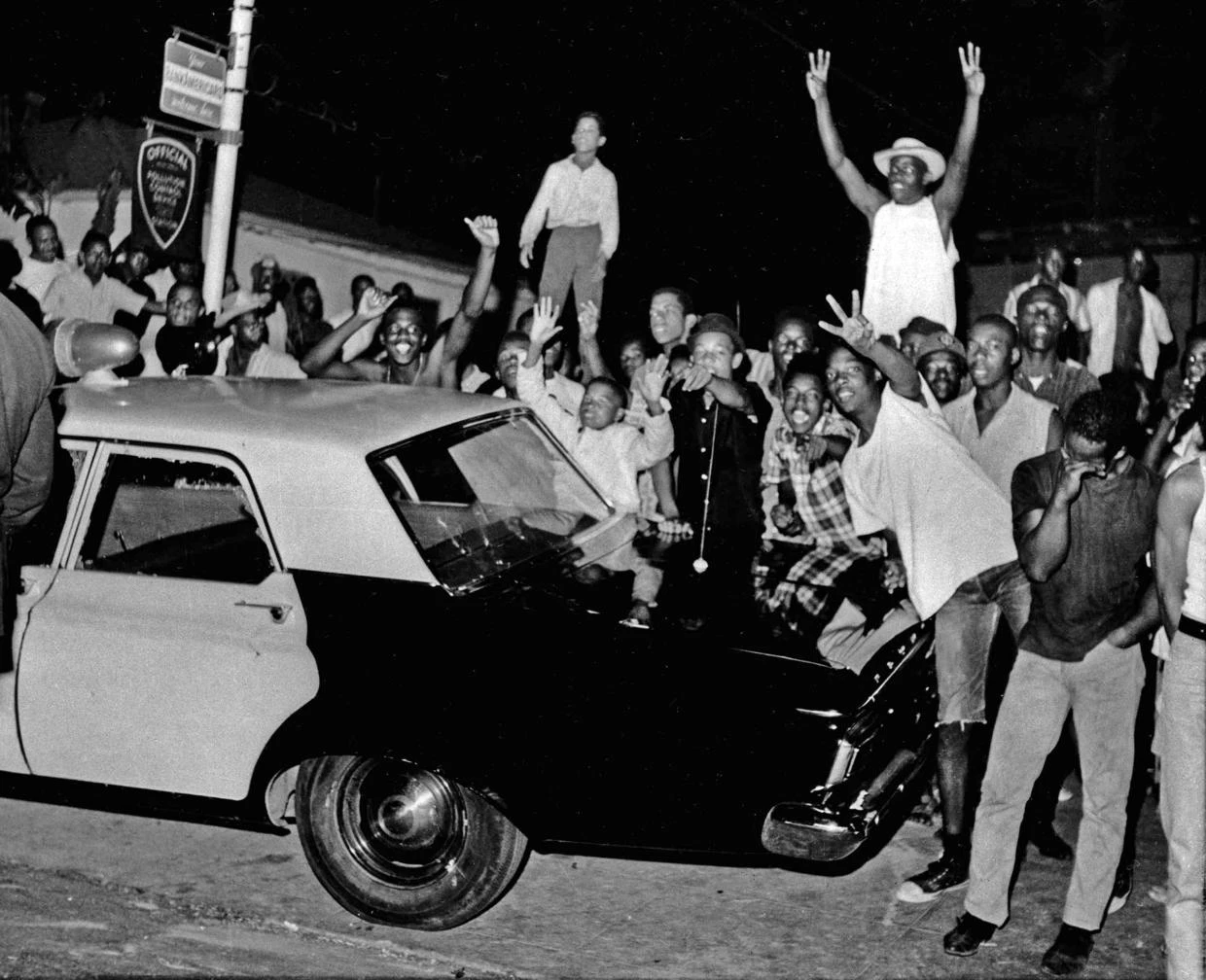 Manifestanti spingono un'auto della polizia durante l'uprising, 12 Agosto 1965. (AP Photo)